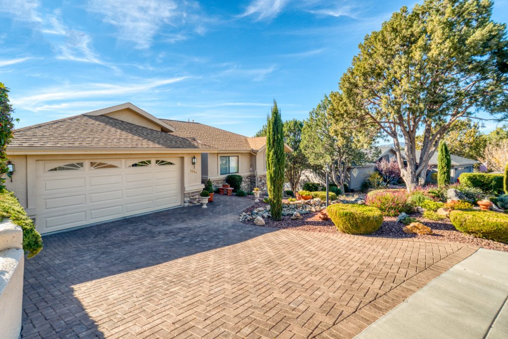 A single-story home with a well-maintained front yard, paved driveway, and a large garage.