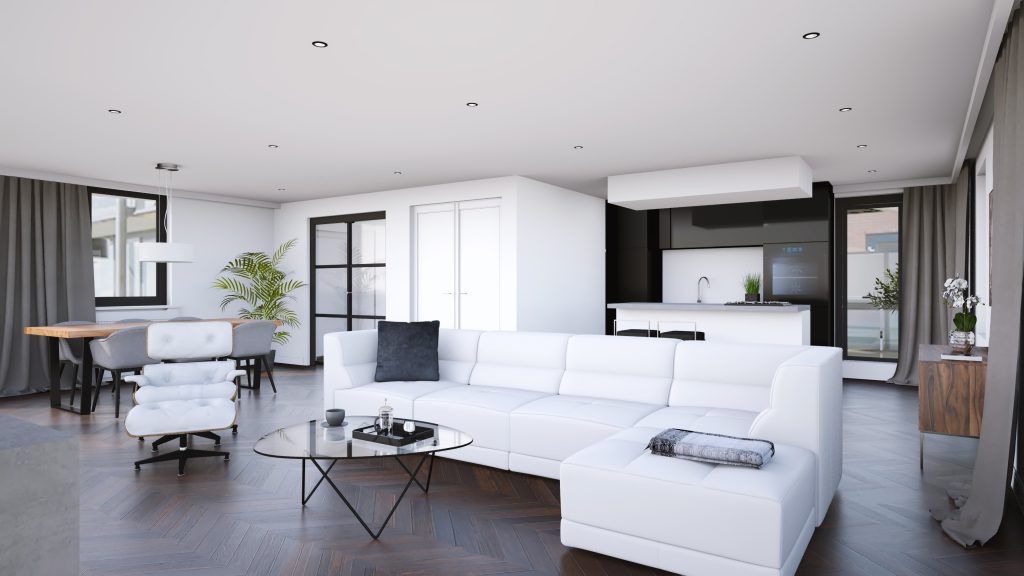 A modern, open-concept living room and kitchen with white furniture, hardwood floors, and large windows providing natural light.