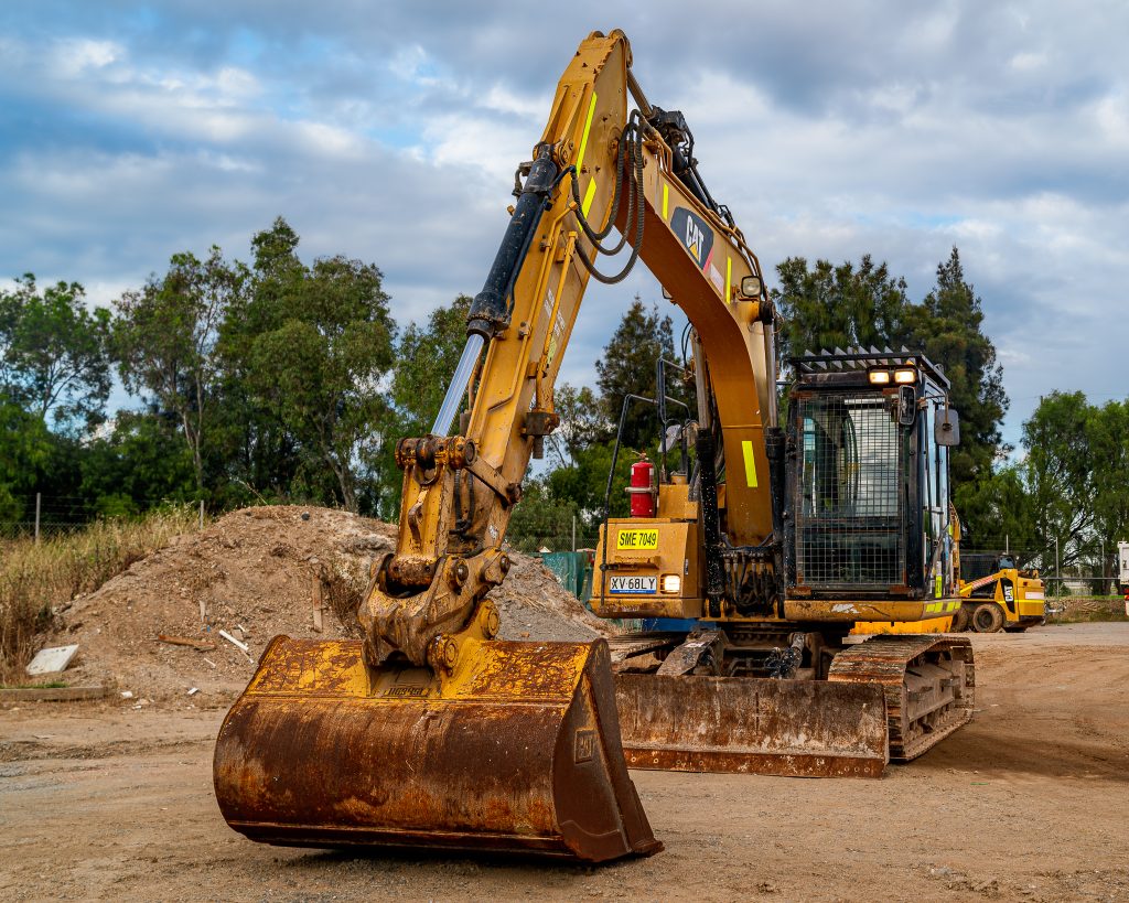 Front view of a CAT 311F excavator at a Coates depot in Adelaide under a clear sky.