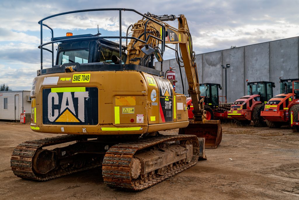 Close-up of the tracks on a CAT 311F excavator, highlighting its wear and rugged design.