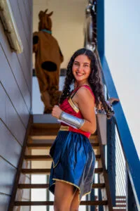 Guest in Wonder Woman costume smiling on holiday park stairs during 25th birthday.
