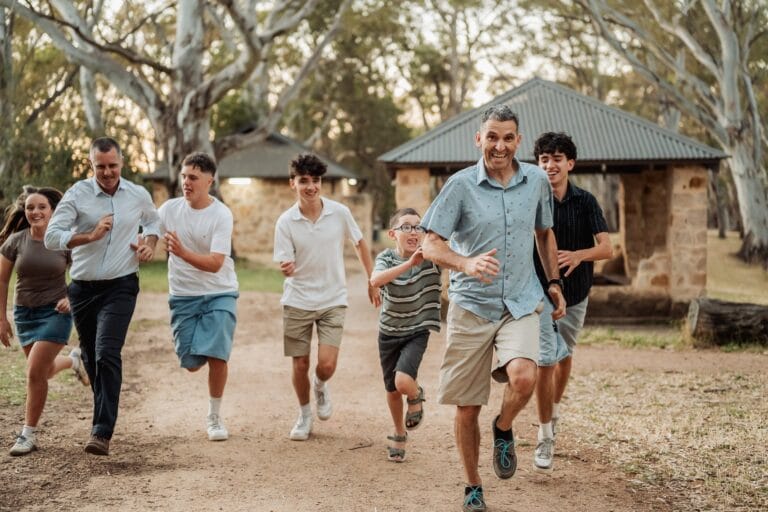 Family running together during an interactive 80th birthday family photography session at Morialta