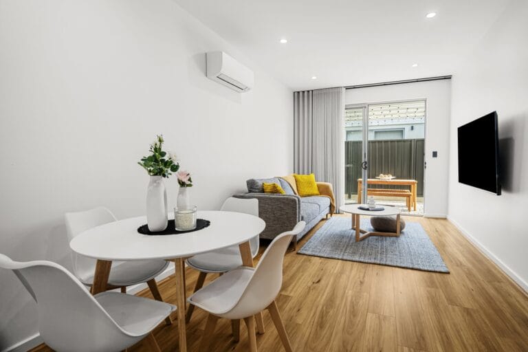 Open-plan living and dining area in a styled two-bedroom apartment in Flinders Park